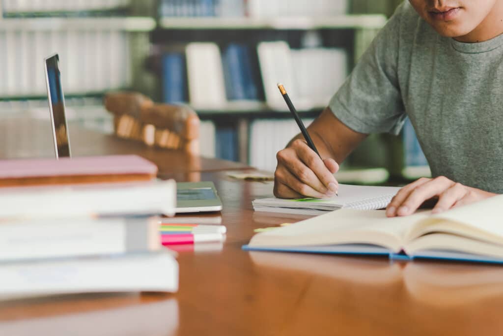 Male student writing about book